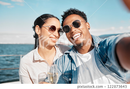 Couple selfie on yacht in ocean celebrate with champagne on vacation or holiday in summer. Happy young man with luxury wine, cruise at sea with woman for celebration or honeymoon travel on ship 122873643