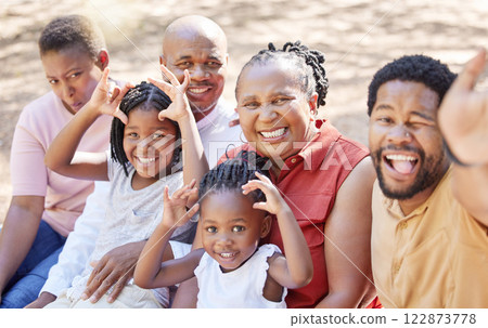 Portrait, happy black family and smile for selfie sitting and bonding in free time together in the outdoors. African father taking a silly photo with kids, wife and grandparents on a summer vacation Portrait, happy black family and smile for selfie sitting and bonding in free time together in the outdoors. African father taking a silly photo with kids, wife and grandparents on a summer vacation 122873778
