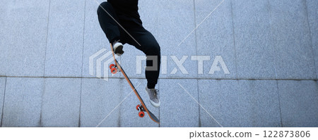 Asian woman skateboarder skateboarding in modern city Asian woman skateboarder skateboarding in modern city 122873806