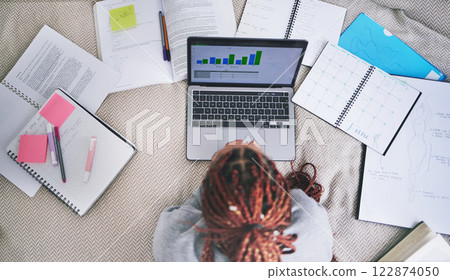 College education and study laptop on bed with school books and sticky notes in home. University student studying graph, analytics and reading digital learning notes for exam preparation. 122874050