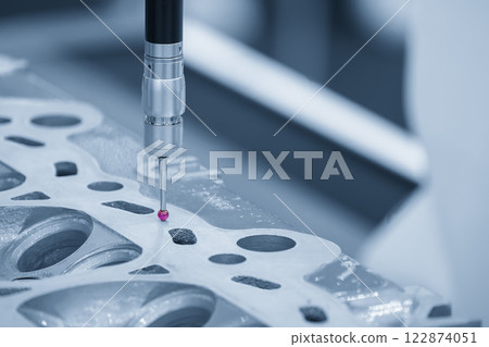 The CMM machine measuring the aluminum cylinder head parts in the light blue scene. 122874051