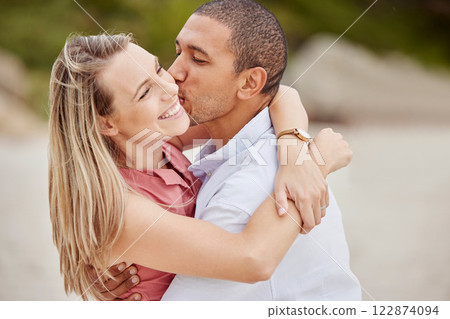 Smile, love and happy couple kiss on the cheek on honeymoon vacation outdoors to celebrate their marriage. Happiness, interracial and smiling woman enjoys traveling on romantic trip with her partner 122874094