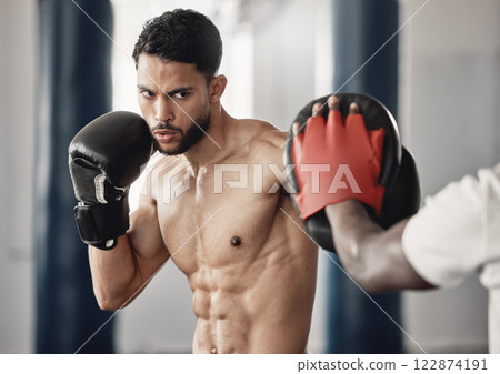 Fitness, training and a man boxing in gym with personal trainer and sparring pads. Health, motivation and exercise, boxer throwing a punch. Fight, muscle and workout with sports gloves in mma studio. Fitness, training and a man boxing in gym with personal trainer and sparring pads. Health, motivation and exercise, boxer throwing a punch. Fight, muscle and workout with sports gloves in mma studio. 122874191