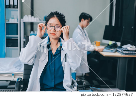 Positive doctor working on laptop in medical office, portrait. Positive doctor working on laptop in medical office, portrait. 122874657