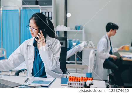 Positive doctor working on laptop in medical office, portrait. 122874660