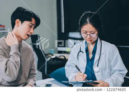 Female physician reads medical history while visiting her patient 122874685