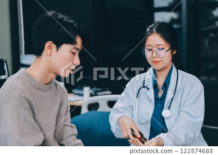 Female physician reads medical history while visiting her patient 122874688