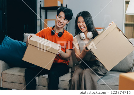 Smiling couple unpacking boxes in new house 122874715