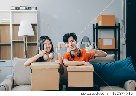 Smiling couple unpacking boxes in new house 122874716