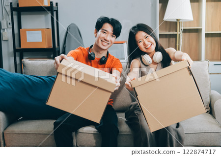 Smiling couple unpacking boxes in new house 122874717