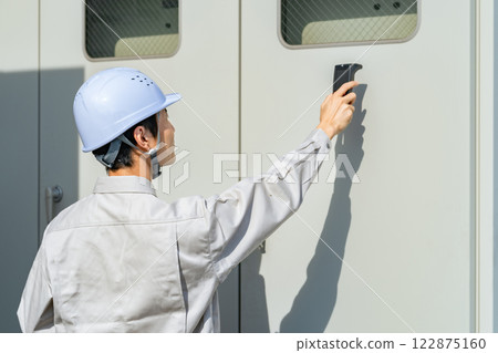 Engineer inspecting equipment using inspection equipment 122875160