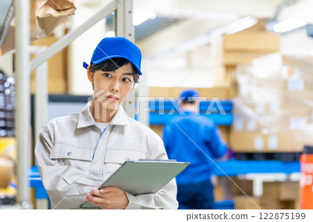 A worker who checks inventory in a warehouse A worker who checks inventory in a warehouse 122875199