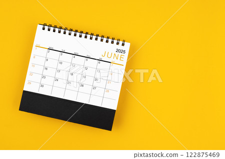 June 2025 desk calendar on yellow background, position with copy space. 122875469