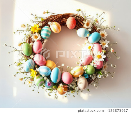 Round Easter wreath made of multi-colored Easter eggs and decorated with delicate spring flowers. 122875917
