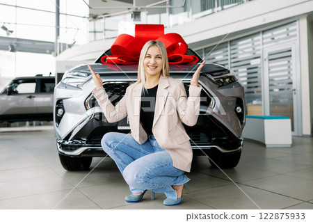 Business woman receiving new car as a gift in dealership 122875933