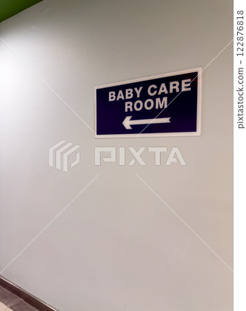 Sign on wall of baby care room and an arrow indicating direction 122876818