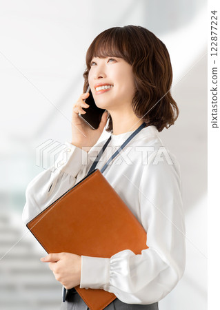 微笑的女人/女商人在智慧型手機上交談 122877224