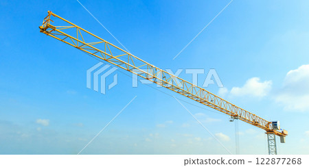 Industrial construction crane with blue sky background at building site 122877268