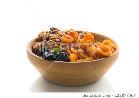 Prunes, dried apricots and nuts in a wooden bowl on a white background 122877367