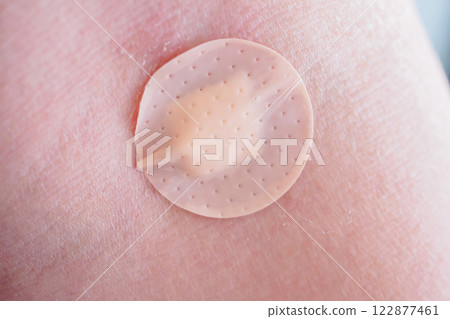 Round adhesive plaster on man arm close up Round adhesive plaster on man arm close up 122877461