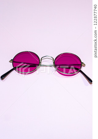 Purple round sunglasses on a pink background Purple round sunglasses on a pink background 122877740