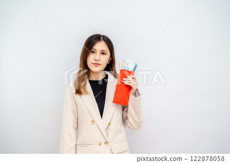 Taiwanese girl holding red envelope with money, Chinese New Year red packet with cash, bonus and salary concept - financial success and wealth 122878058