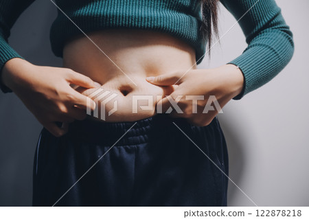 Asian Woman Pinching Her Belly Fat With Left Hand 122878218