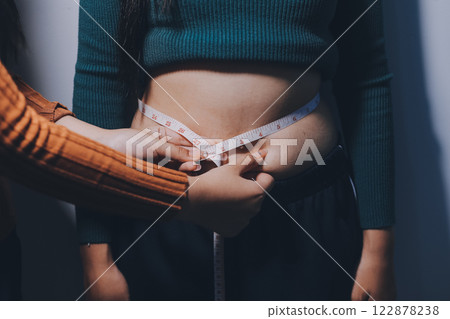 Asian Woman Pinching Her Belly Fat With Left Hand 122878238
