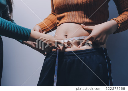 Asian Woman Pinching Her Belly Fat With Left Hand Asian Woman Pinching Her Belly Fat With Left Hand 122878266