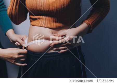 Asian Woman Pinching Her Belly Fat With Left Hand 122878269