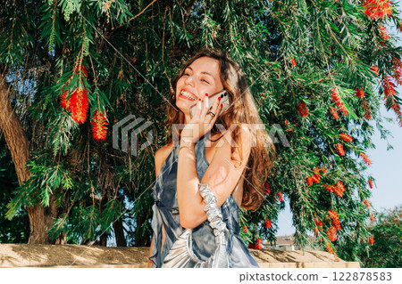 Effortless digital lifestyle: a modern woman in nature, blending technology, fashion, and the 122878583