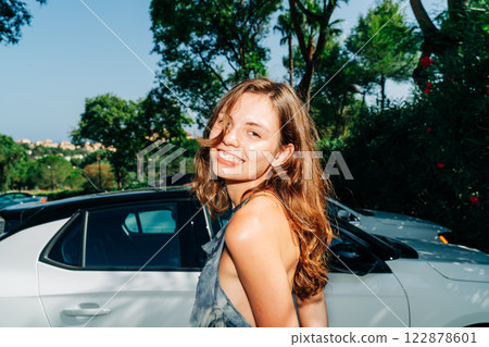 Sunlit confidence: a radiant smile, golden-hour glow, and modern elegance, blending automotive Sunlit confidence: a radiant smile, golden-hour glow, and modern elegance, blending automotive 122878601