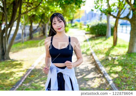 A cool woman jogging on a road with sunlight filtering through the trees Walking Diet Exercise Exercise A cool woman jogging on a road with sunlight filtering through the trees Walking Diet Exercise Exercise 122878604