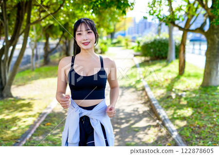 陽光透過樹叢灑在路上，一位酷酷的女士在路上慢跑 散步 節食 鍛煉 鍛煉 122878605
