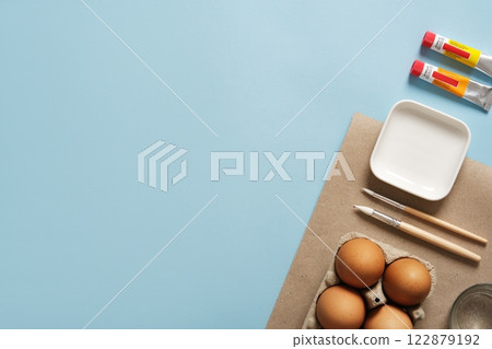 Preparation for Easter celebration. Painting Easter eggs with acrylic pigment dyes in tubes. Clean brown eggshells. 122879192