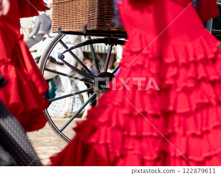 Traditional flamenco dress and carriage wheel at fair Traditional flamenco dress and carriage wheel at fair 122879611