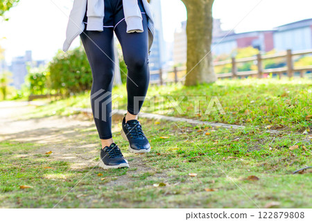 A cool woman jogging on a road with sunlight filtering through the trees Walking Diet Exercise Exercise Trimming A cool woman jogging on a road with sunlight filtering through the trees Walking Diet Exercise Exercise Trimming 122879808