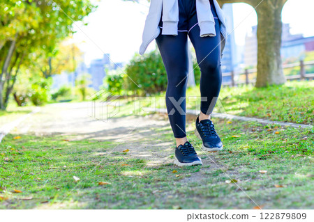 陽光透過樹叢灑在路上，一位酷酷的女士在路上慢跑 散步 節食 運動 鍛煉 減肥 122879809