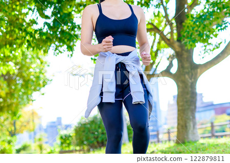 A cool woman jogging on a road with sunlight filtering through the trees Walking Diet Exercise Exercise Trimming A cool woman jogging on a road with sunlight filtering through the trees Walking Diet Exercise Exercise Trimming 122879811