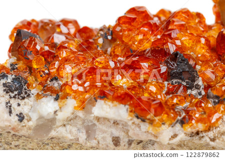 macro mineral stone Spessartine, orange, red garnet with quartz on white background 122879862