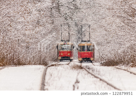 An old tram moving through a winter forest 122879951