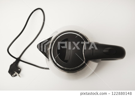 Electric kettle on a white background. A metal teapot with a black handle. Electric kettle on a white background. A metal teapot with a black handle. 122880148