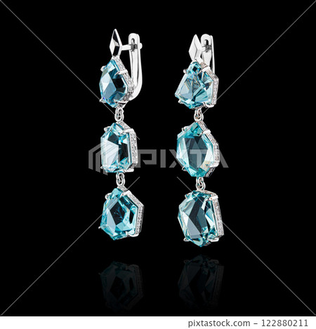 Beautiful gold earrings with aquamarine and diamonds on a black background 122880211