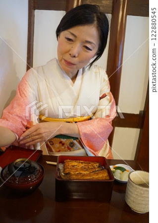 A woman in a kimono pouring tea 122880545