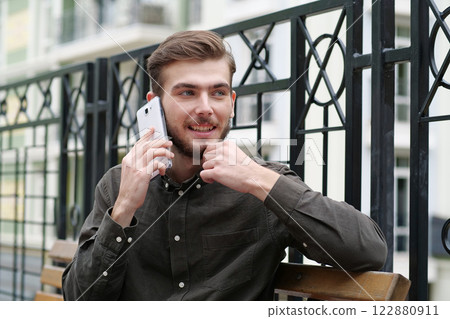 Young businessman talks on smartphone 122880911