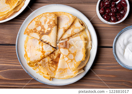 Homemade crepes pancakes with sour cream and cherry syrup 122881017