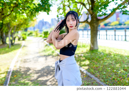 A cool woman jogging on a road with sunlight filtering through the trees Posing Diet Exercise 122881044