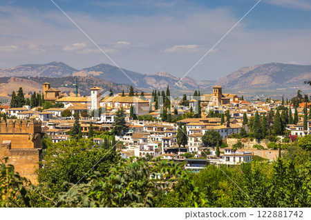 Granada town in Spain. Picturesque town nestled in mountains under a bright sunny sky. Granada town in Spain. Picturesque town nestled in mountains under a bright sunny sky. 122881742