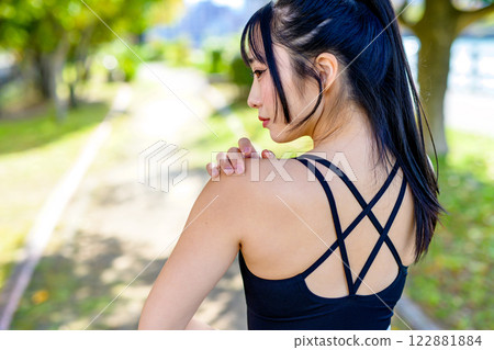 一個有著美麗背部的酷女人在陽光下的路上鍛煉，散步，鍛煉，鍛煉 122881884