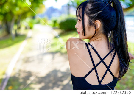 A cool woman with a beautiful back exercising on a road in the sunlight, walking, exercise, exercise 122882390